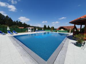 a swimming pool with chairs and a gazebo at Feriendorf Fuchsberg in Schirgiswalde