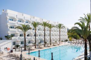 uma imagem de um hotel com piscina e palmeiras em Alanda Marbella Hotel em Marbella
