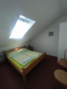a small bedroom with a bed with a skylight at Haškovna - tradice zájezdního hostince u Prachovských skal in Ohaveč