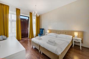 a bedroom with a large bed and yellow curtains at Garni Hotel VIRGO in Bratislava