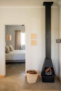 ein Zimmer mit einem Kamin und ein Schlafzimmer mit einem Bett in der Unterkunft Melkhout River Cottage in Bonnievale