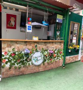 a restaurant with a counter with flowers on it at Hotel Colonial Armenia RO in Armenia