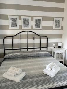 a bedroom with a bed with two towels on it at Amba Alagi Apartment in Genova