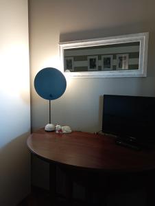 a desk with a television and a lamp on it at Amba Alagi Apartment in Genoa