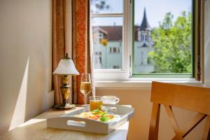 a table with a plate of food and a glass of wine at Villa Sedan - Destigo Hotels in Sopot +25 photos