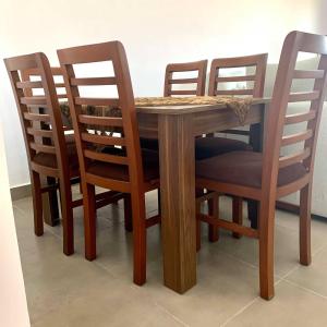 a wooden table with four chairs around it at Amwaj north Coast 