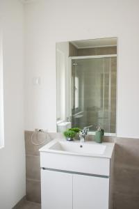 uma casa de banho com um lavatório branco e um espelho. em Aquarela do Tejo Guesthouse em Vila Franca de Xira