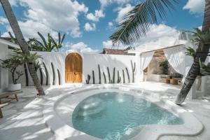 科贾扬Bohemian Jogja Villas with Private Pool的棕榈树庭院中间的游泳池