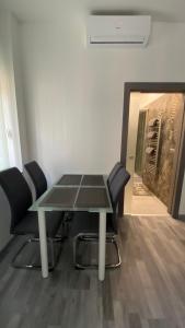 una mesa de cristal y sillas en una habitación en Korányi apartman, en Szeged
