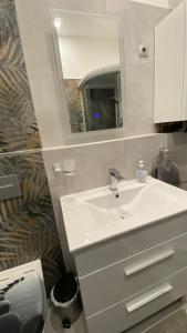 y baño con lavabo blanco y espejo. en Korányi apartman, en Szeged