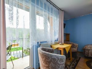 a room with a large window and a table and chairs at U Ziutka in Jurgów