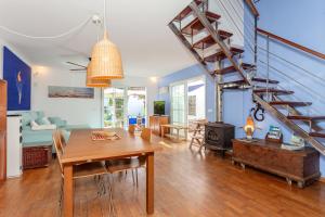 a living room with a table and a staircase at Aloes in Sa Caleta