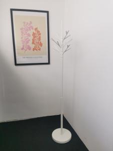 a plant in a white stand next to a picture at Casa Good Vibes in Târgu-Mureş