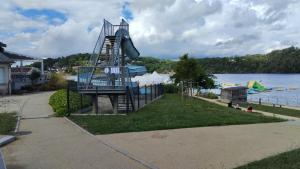 a playground with a slide next to the water at Chez David et Sonia in Éguzon-Chantôme