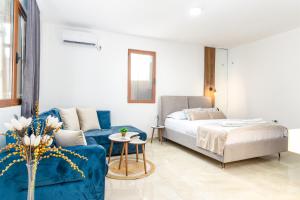 a living room with a blue couch and a bed at Ema'ar Villas in Ulcinj