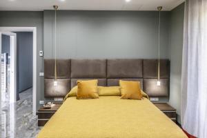 ein Schlafzimmer mit einem großen Bett mit gelben Kissen in der Unterkunft Gold Luxury Flat x4 in Sorrent