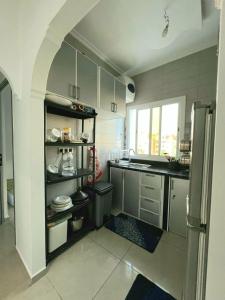 a kitchen with a refrigerator and a counter top at Appartement dans résidence à 2 pas de la mer et parking in Tangier