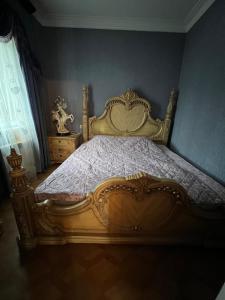 a bed in a bedroom with a gold bed frame at Erik in in Tbilisi City
