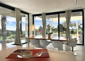 una sala da pranzo con tavolo, sedie e ampie finestre di Casa Tyane a Sant Jordi