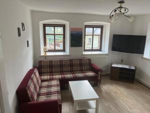 uma sala de estar com um sofá e uma mesa em Apartmán Eliška em Kuks