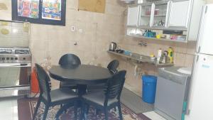 Madinah Anbariah في المدينة المنورة: مطبخ مع طاولة وكراسي وثلاجة