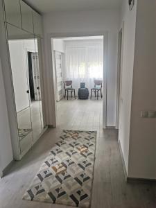 a hallway with a rug on the floor and a mirror at Casa Good Vibes in Târgu-Mureş