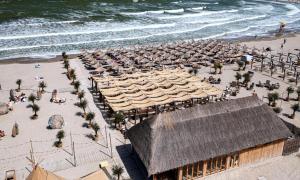 eine Luftansicht auf einen Strand mit Sonnenschirmen und Personen in der Unterkunft NEVERSEA Beach - Panoramic Penthouse in Constanţa