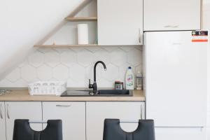 a kitchen with white cabinets and a sink at Apartament nad Ustroniem in Gołdap
