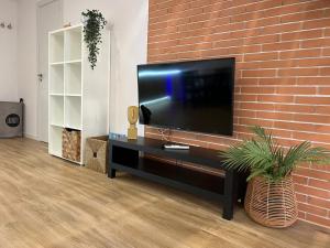 a flat screen tv on a brick wall at Grandera Apart`s - Carbonell 1 in Valencia