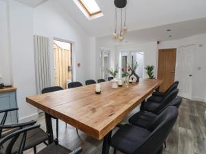 a dining room with a wooden table and black chairs at Seascape Villa in Filey