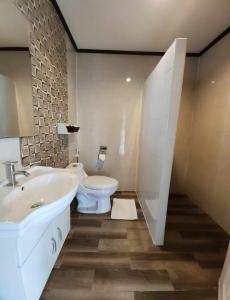 北芭堤雅的住宿－The Tamnan Pattaya Hotel & Resort，浴室配有白色水槽和卫生间。