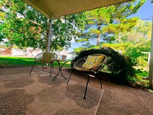two chairs and a table under an umbrella at NEW! Mid-Century Modern Themed Family Home! in Vermilion