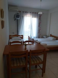 una camera con due letti e un tavolo con sedie di Golden Beach-Tsianis Apartments a Néa Meságkala