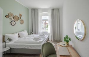 biała sypialnia z łóżkiem i lustrem w obiekcie BENVILLE Meißen - Free Parking - Nespresso Kaffee - Stylisch w mieście Miśnia