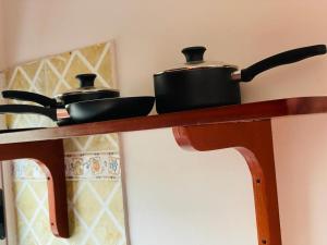 two pots and pans sitting on a wooden shelf at AS Guest House in Libreville +19 photos