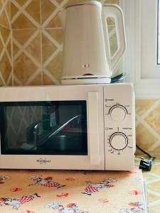 a microwave with a coffee pot on top of it at AS Guest House in Libreville