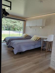 um quarto com 2 camas, uma mesa e uma janela em Hotel OmaBox - Nivala - Oma huoneisto saunalla em Nivala