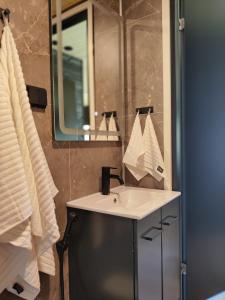 uma casa de banho com um lavatório e um espelho em Hotel OmaBox - Nivala - Oma huoneisto saunalla em Nivala