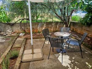 a patio with a table and chairs and an umbrella at Apartment Tomas,,,Spacious house with private parking,terrace,5G Internet,,,,, in Zadar