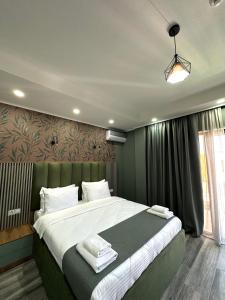 um quarto com uma cama grande e paredes verdes em Luxmani Hotel & Spa em Tbilisi