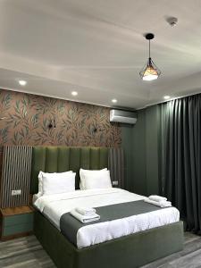 a bedroom with a large bed with a green headboard at Luxmani Hotel & Spa in Tbilisi City