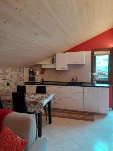 リヴィーニョにあるEMMA Vacanzeの白いキャビネットとテーブル付きのキッチンが備わります。