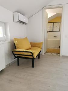 a couch with a yellow pillow in a room at Casa Good Vibes in Târgu-Mureş