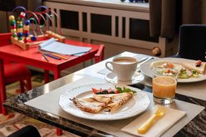 a table with two plates of food and a cup of coffee at Villa Sedan - Destigo Hotels in Sopot