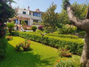 a garden with flowers and a house in the background at La capannina cilento cam 12 in San Marco di Castellabate