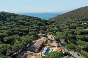 an aerial view of a town with trees and the ocean at Hôtel L'Escalet in Ramatuelle