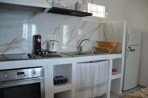 a white kitchen with a sink and a stove at Summer Residence in Provatas