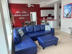 a living room with a blue couch and a kitchen at The Aviator's Club - Central Downtown Sandusky in Sandusky