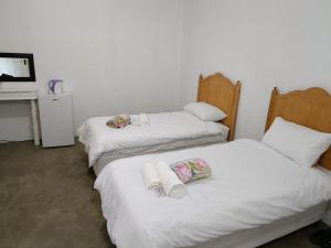 3 łóżka w pokoju z białą pościelą i ręcznikami w obiekcie Fountain Villa w mieście Klerksdorp