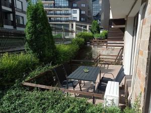 d'une terrasse avec une table, des chaises et des escaliers. dans l'établissement LOREA Apartment L000 in Aspen Golf Resort, à Razlog